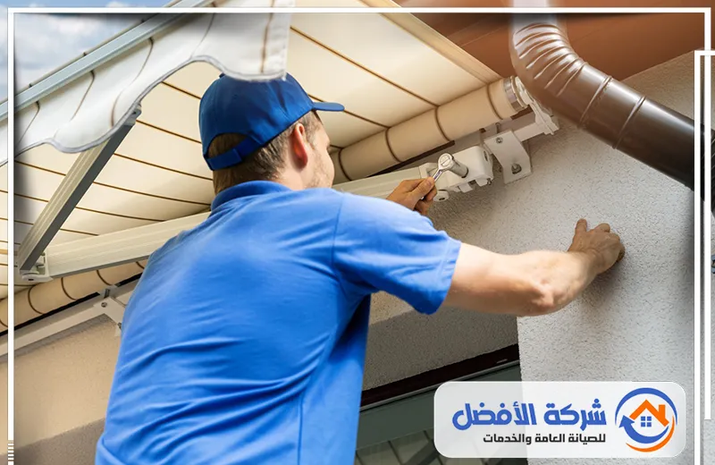 مظلة واسعة ذات تصميم هرمي أو مخروطي، ترتكز على أربع أعمدة دعم قوية بلون البيج الفاتح.