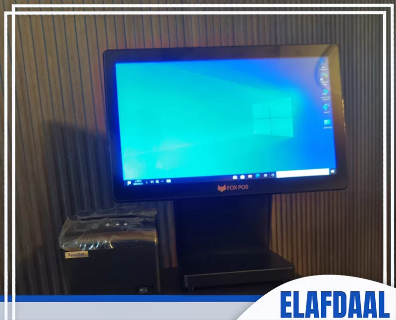 نظام كاشير سريع وعملي لتنظيم عمليات البيع والشراء جهاز نقاط البيع (POS) مع شاشة تعمل بتقنية اللمس، حيث يظهر شعار "FOX POS" على الشاشة. يوجد بجانب الجهاز طابعة متصلة به لطباعة الفواتير، متوفر في شركة الافضل.
