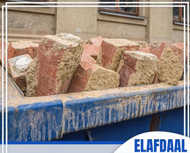 تجميع مخلفات الطوب والرمل داخل حاوية مخصصة لنقل نفايات البناء من الموقع