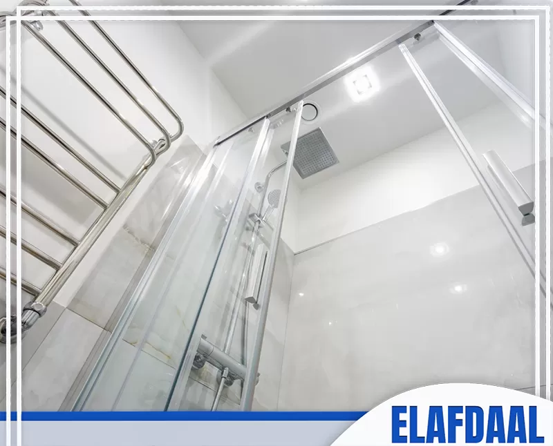 منع تسرب المياه في شاور بوكس زجاج بجدة 0547648005 شركة الأفضل كابينة شاور زجاجية داخل حمام حديث، مع دش علوي وزجاج شفاف وإكسسوارات معدنية مثبتة حول منطقة الاستحمام.
